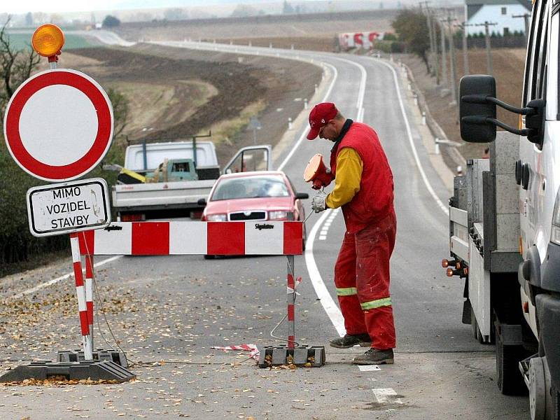 Dělníci stavební firmy odstraňují zátaras, který od června bránil řidičům v průjezdu staveniště. Mnozí očekávali zprůjezdnění hlavní trasy z Třebíče na Moravské Budějovice s velkou nedočkavostí.