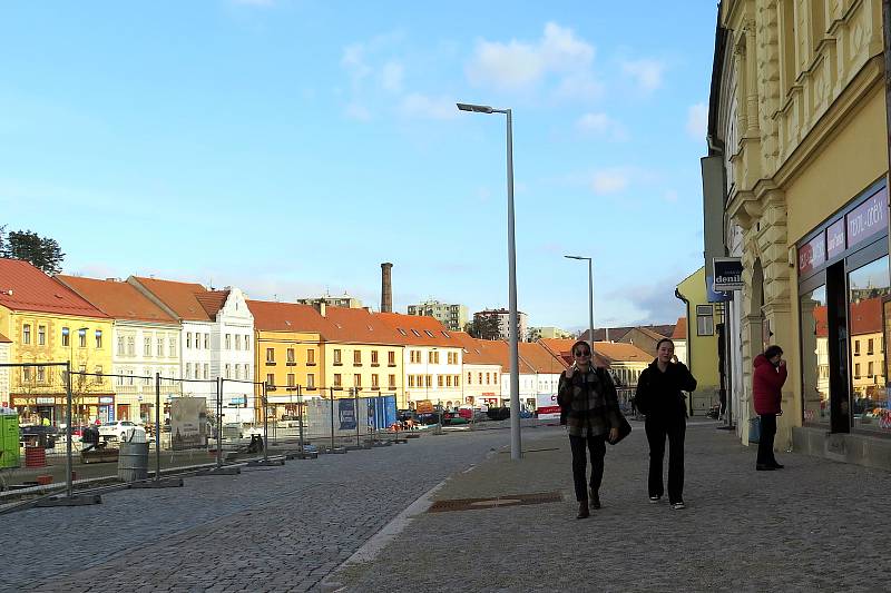 Vozovka i chodník na náměstí mezi Přerovského a Hasskovou ulicí už jsou hotové. Neukáznění řidiči dodávek však najížděli na chodník, čímž poškodili litinové mříže, které budou chránit zasazené stromy.