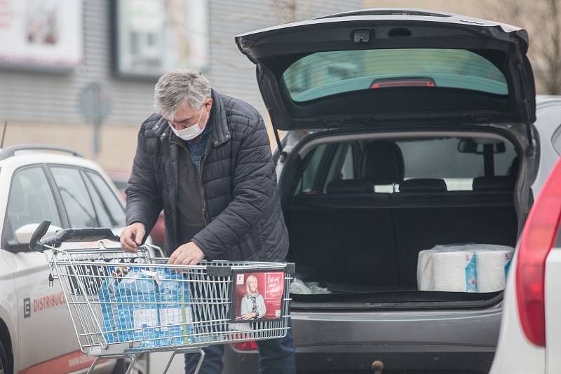 Lidé se při nákupech chrání rouškami a podobnými ochrannými pomůckami.