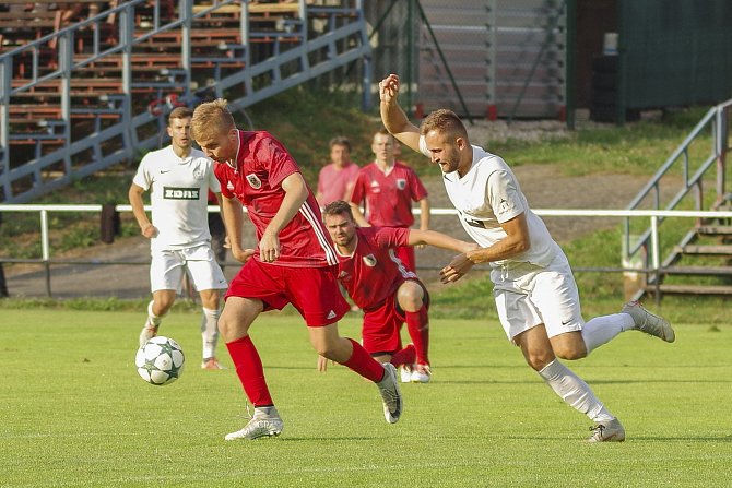 Poprvé za několikaleté působení v moravskoslezské divizi se fotbalistům Bystřice (v červeném) podařilo vybojovat na hřišti Tasovic všechny tři body.