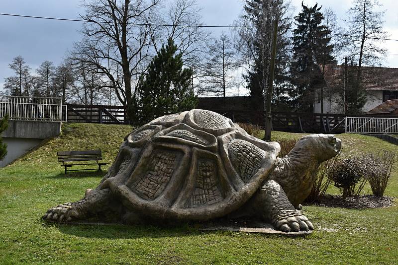 Obří betonová želva je umístěna v parku u řeky.