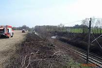 Požár trávy podél železniční tratě u Vlkova.