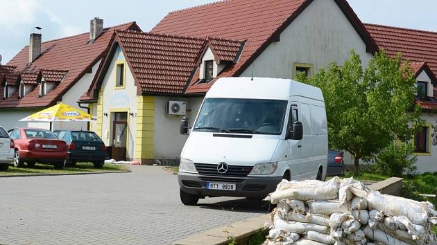 Pytle s pískem zůstávají přede dveřmi cukrárny v Santiniho ulici i nadále. Představují pojistku, kdyby přišla další bouřka s přívalovým deštěm. 