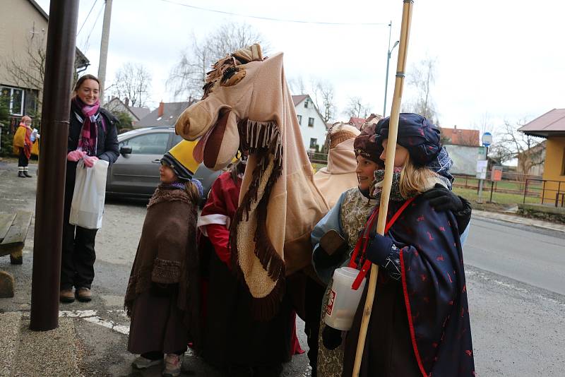 Ulicemi procházejí tři králové se svým doprovodem.