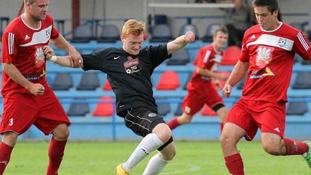 Fotbalisté juniorky Velkého Meziříčí (ve červených dresech) vyhráli podruhé v řadě a rázem se vyhoupli do první poloviny tabulky.