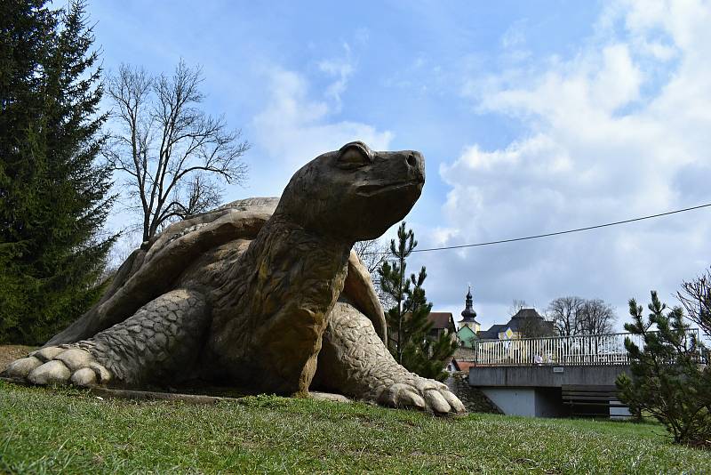 Obří betonová želva je umístěna v parku u řeky.