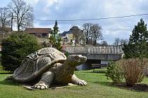 Obří betonová želva je umístěna v parku u řeky.