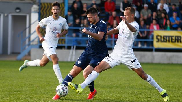 Loni v září podlehli fotbalisté Nového Města (v modrém útočník Tomáš Duba) na domácí půdě juniorce Slovácka (v bílém) těsně 1:2. V pátek budou mít možnost jim tuto prohru vrátit.