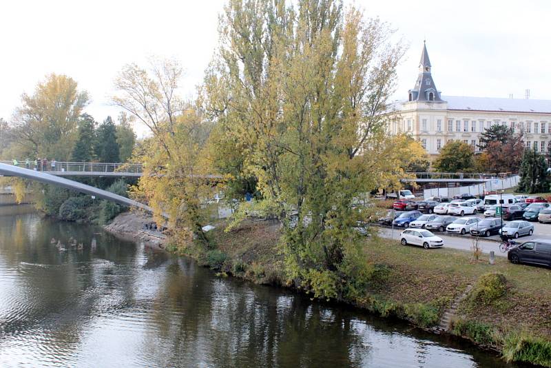 Práce na konci října roku 2021 na stavbě nové lávky přes řeku Labe v Nymburce: úpravy povrchu na samotné lávce, dodělávání příjezdových cest, dláždění přímo pod lávkou na březích.