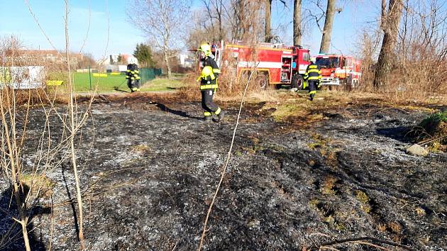 Požár trávy nedaleko nedostavěných doků v Drahelicích.
