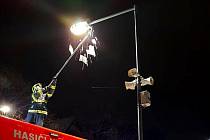 Hasiči při shazování rampouchů z lampy veřejného osvětlení v Nymburce.