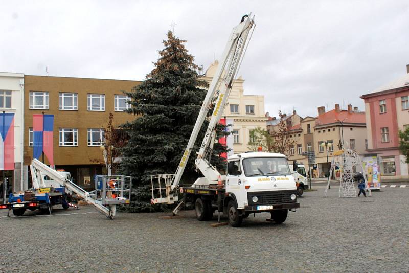 V pátek dorazil na nymburské náměstí letošní vánoční strom a v pondělí už kolem něj omotávají pracovníci technických služeb první výzdobu.
