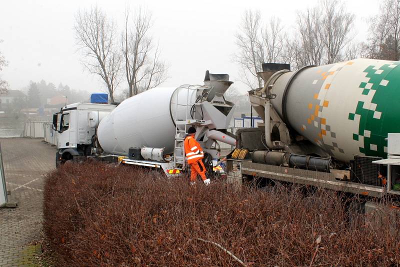 Ve čtvrtek před polednem jsme s naším objektivem vyfotili práce nad parkovištěm u Labe, kde z obřích míchaček a jejich hadic tekl beton do připravené konstrukce.