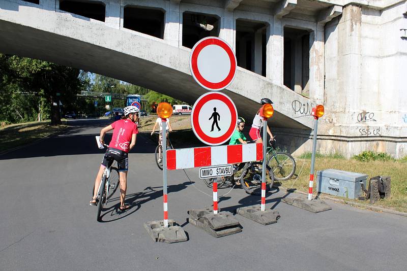 Dělníci už rozestavují plochy kolem širší plochy staveniště, cyklisté se vracejí už od kamenného mostu.