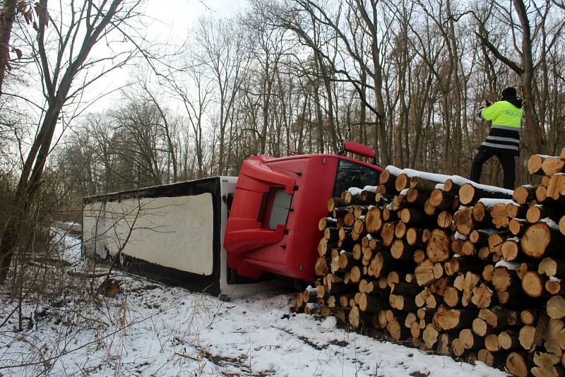 Kamion skončil na pravém boku a jeho cesta příkopem se zarazila až o hromadu nařezaného dřeva na kraji lesa Holička.