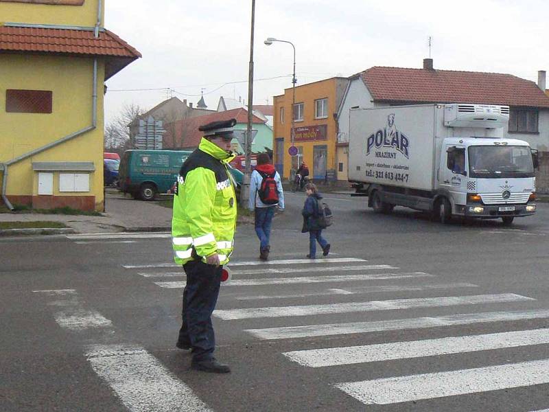 Na křižovatce v Sadské musí ráno strážník pomoci školákům bezpečně přejít. Kruhový objezd jen tak nebude.