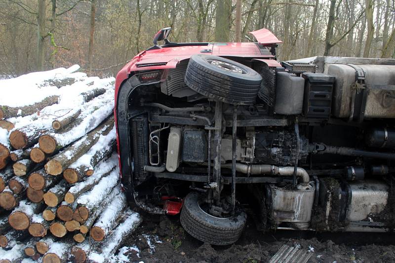 Kamion skončil na pravém boku a jeho cesta příkopem se zarazila až o hromadu nařezaného dřeva na kraji lesa Holička.