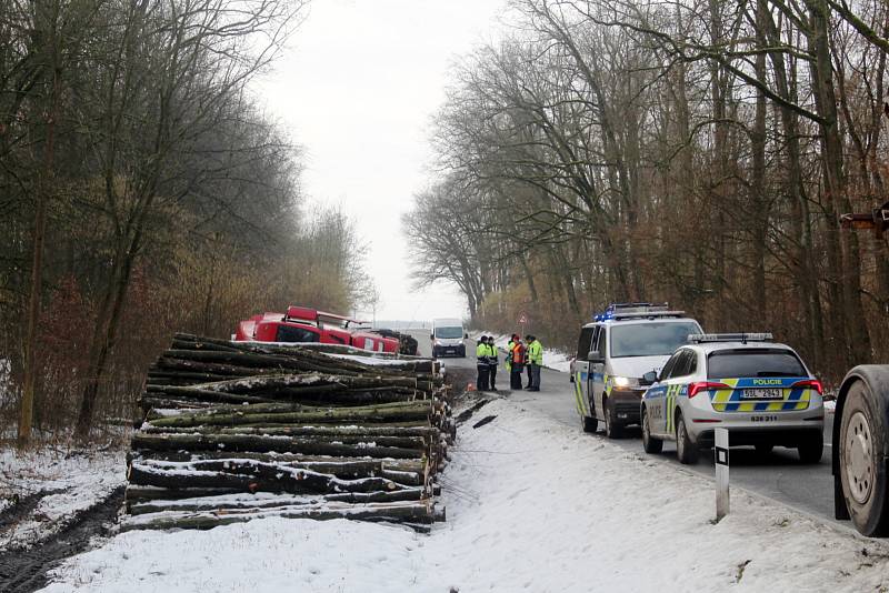 Kamion skončil na pravém boku a jeho cesta příkopem se zarazila až o hromadu nařezaného dřeva na kraji lesa Holička.