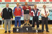 Na stupních vítězů se v kategorii do 67,5 kg sešli druhý Karel Ruso, první Darren Matsumoto (USA) a třetí Jan Roytvand (NOR). Úplně vlevo je předseda českého svazu silového trojboje Miroslav Vacek. Na opačné straně fotografie je delegát IPF Gaston Parage.