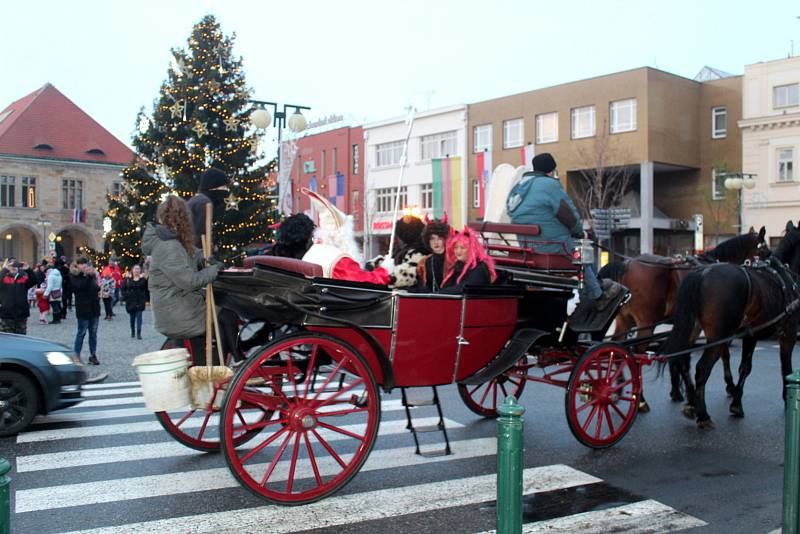 Čerty, Mikuláše a anděla přivezl  v neděli 5. prosince 2021 na nymburské náměstí povoz tažený dvěma koňmi.