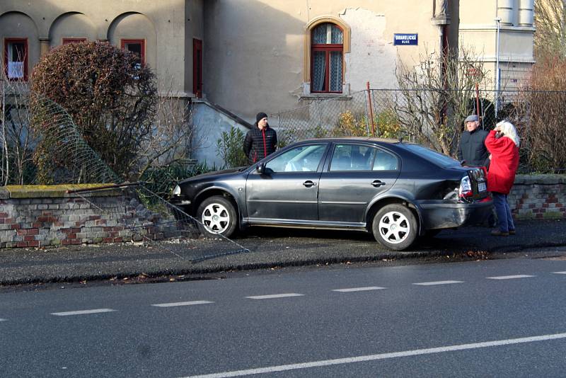 Po smyku skončil řidič v plotu rodinného domu.