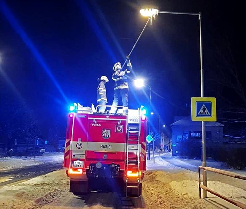 Hasiči při shazování rampouchů z lampy veřejného osvětlení v Nymburce.