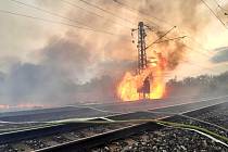 Vysoké plameny šlehající z rákosí u trati nedaleko Libice nad Cidlinou a následná likvidace požáru.