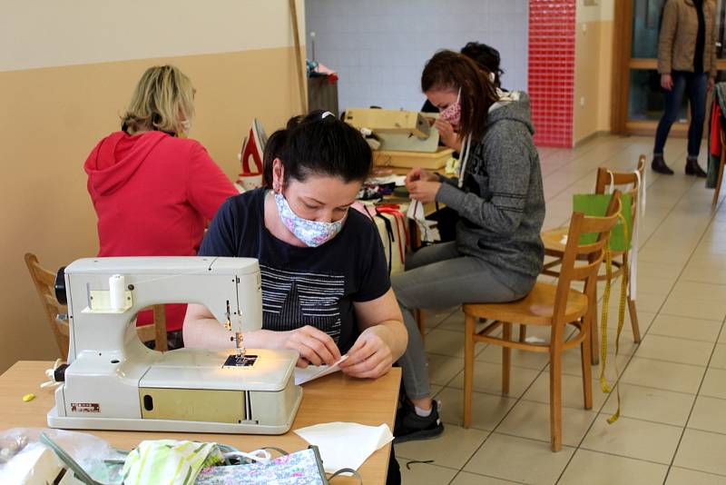 V Dymokurech šijí roušky ve školní kuchyni, část z nich pak věší na rouškovník před školou.