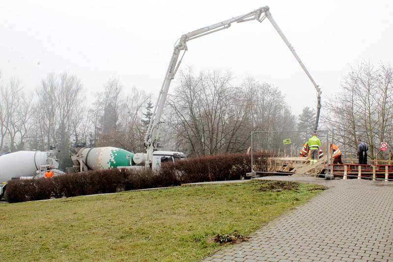 Ve čtvrtek před polednem jsme s naším objektivem vyfotili práce nad parkovištěm u Labe, kde z obřích míchaček a jejich hadic tekl beton do připravené konstrukce.