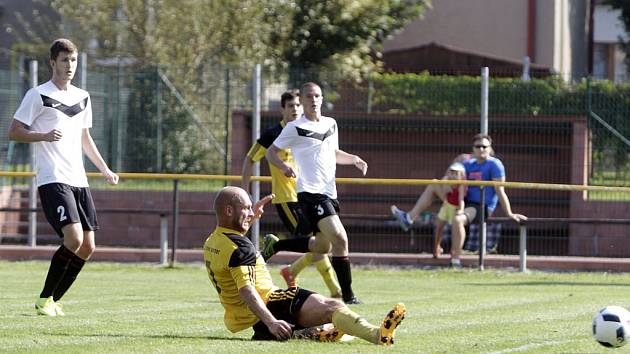 Olomoucký divizní tým Nové Sady (ve žlutém) podlehl rezervě Opavy 1:3. Tomáš Režný (ve skluzu).