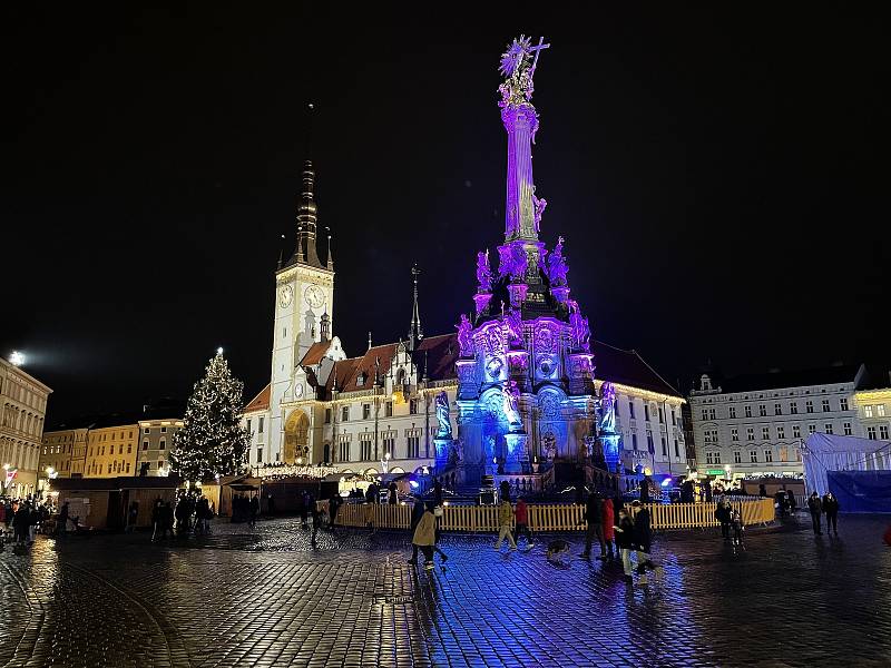 Nasvětlený Sloup Nejsvětější Trojice na Horním náměstí v Olomouci mění barvy. Prosinec 2021
