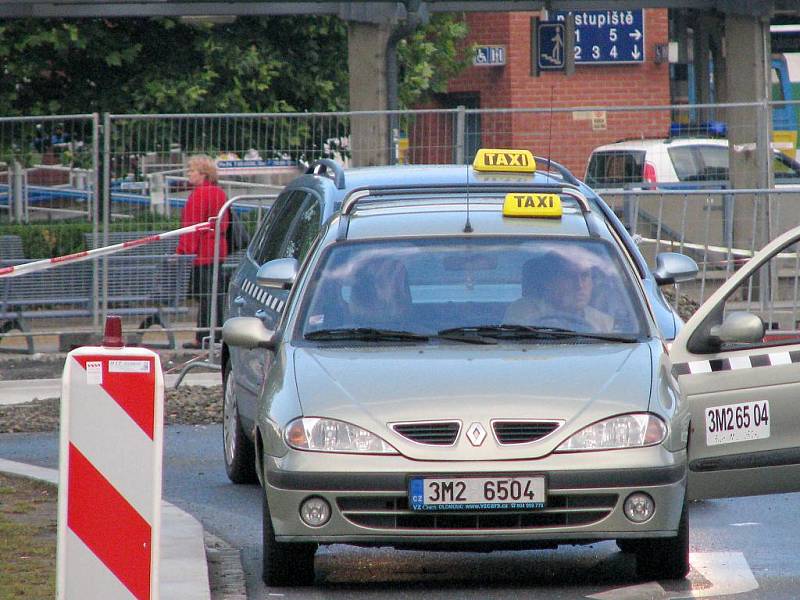 Taxi čekající na zákazníky na rozkopaném přednádraží 