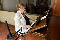 Kastelánka Bouzova Zuzana Šulcová, která ovládá hru na klavír, u restaurovaných varhan v hradní kapli na Bouzově