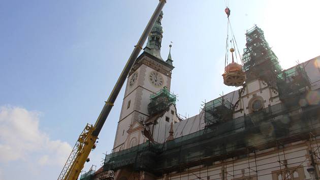 Opravená radniční věžička se v úterý dopoledne vrátila na své původní místo. Plné Horní náměstí v Olomouci přihlíželo, jak ji nahoru zvedá obrovský jeřáb.