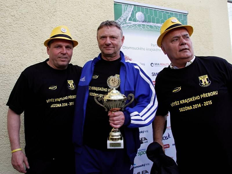 Fotbalisté Nových Sadů (ve žlutém) porazili Dolany 8:1 a radovali se z vítězství v soutěži.  trenér Karel Trnečka s pohárem