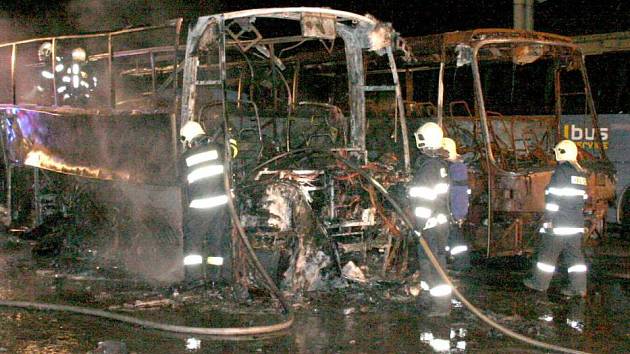 Vyhořelý autobus v areálu v Pavelkově ulici stojí vedle vozidla, které plameny zničily na stejném místě loni v prosinci.