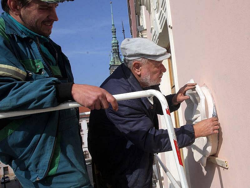 Sochař Oldřich Vícha instaluje znamení na dům U Bílé růže na Dolním náměstí