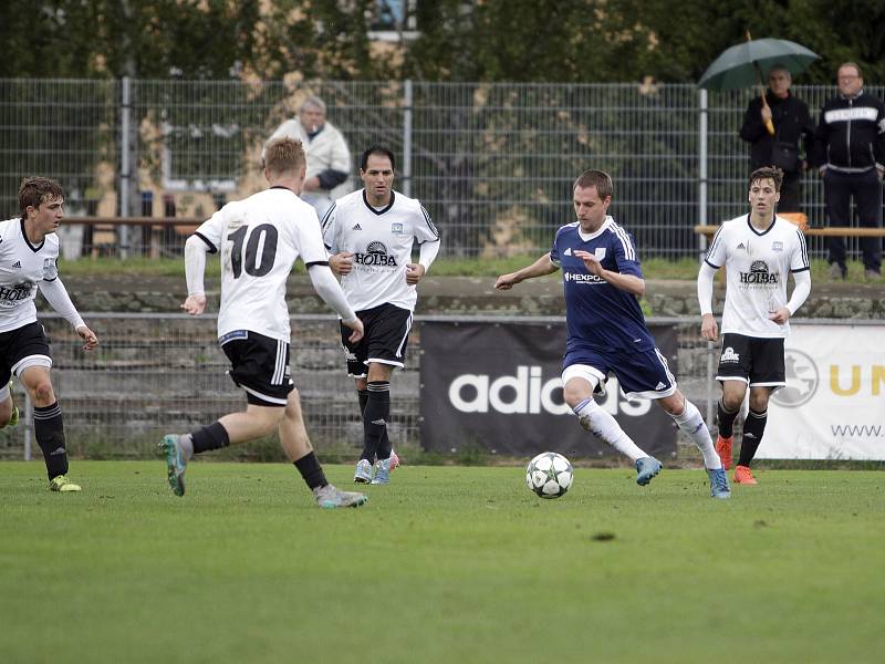 Fotbalisté Uničova remizovali s Rýmařovem (v bílém) 1:1. Tomáš Nuc (u míče)