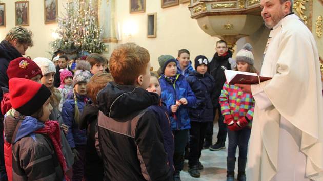 Děti i dospělí naslouchali slovům faráře na dětské mši na Štědrý den v Těšeticích.