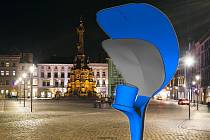 Lampa "plácačka" v koláži s Horním náměstím v Olomouci. Srovnání původního tvaru lampy (modře) a nového upraveného návrhu (šedě)