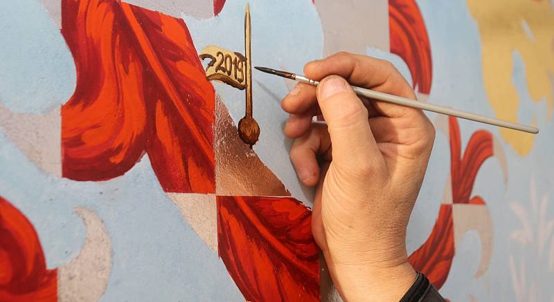 Akademický malíř Radomír Surma dokončuje sluneční hodiny na olomoucké radnici.