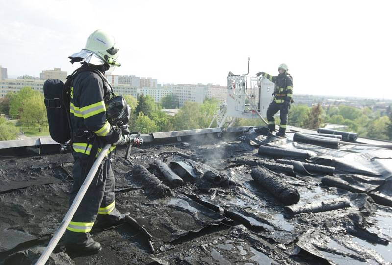 Požár střechy panelového domu v Polabinách. Právě se zde pokládala nová střecha.