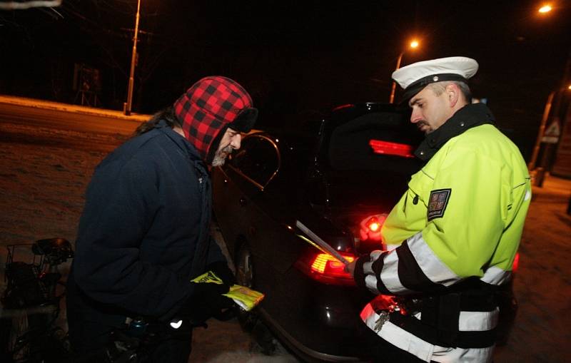 Při kontrole osvětlení jízdních kol rozdávali policisté pokuty i praktické reflexní doplňky.