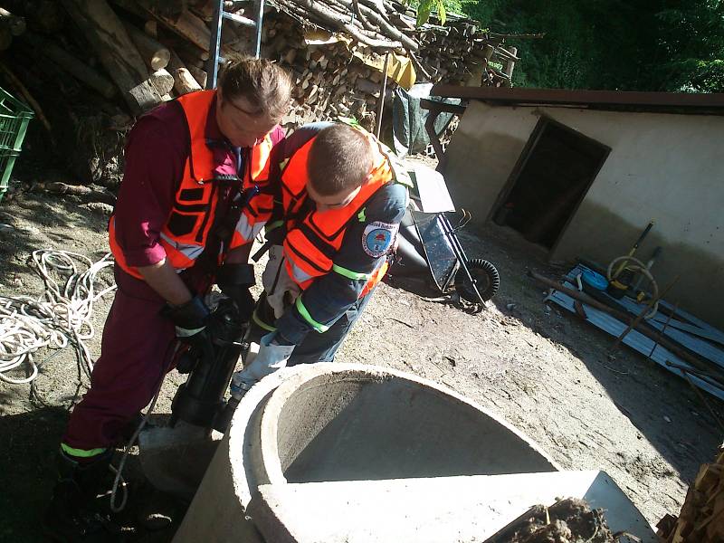 Dobrovolní hasiči z Lázní Bohdaneč pomáhají čistit studnu.