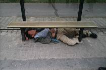 Opilý cizinec se zvládl zasoukat pod lavičku na zastávce.