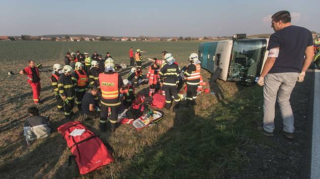 Vážná nehoda na Holicku. Autobusu s padesáti lidmi za jízdy zřejmě praskla pneumatika a převrátil se do pole.