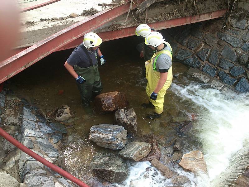 Dobrovolní hasiči z Lázní Bohdaneč pomáhají s vyklízením ucpaného tunelu.