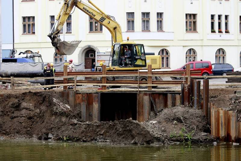 Dálkově ovládaný bagr čistí dno řeky od nánosů bahna