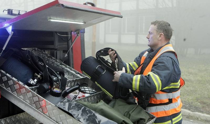 Požár skladištní haly v Černé za Bory. Hasiči museli v dýchací technice zasahovat v hustém dýmu. 