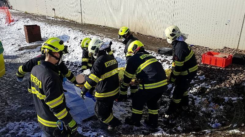 Dělník uvízl mezi stavební buňkou a mostní konstrukcí.